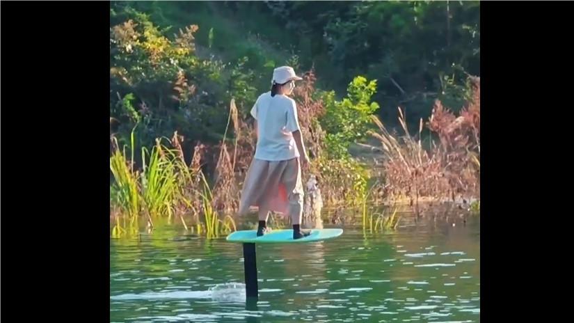 Woman handles hydrofoil surfboard with ease