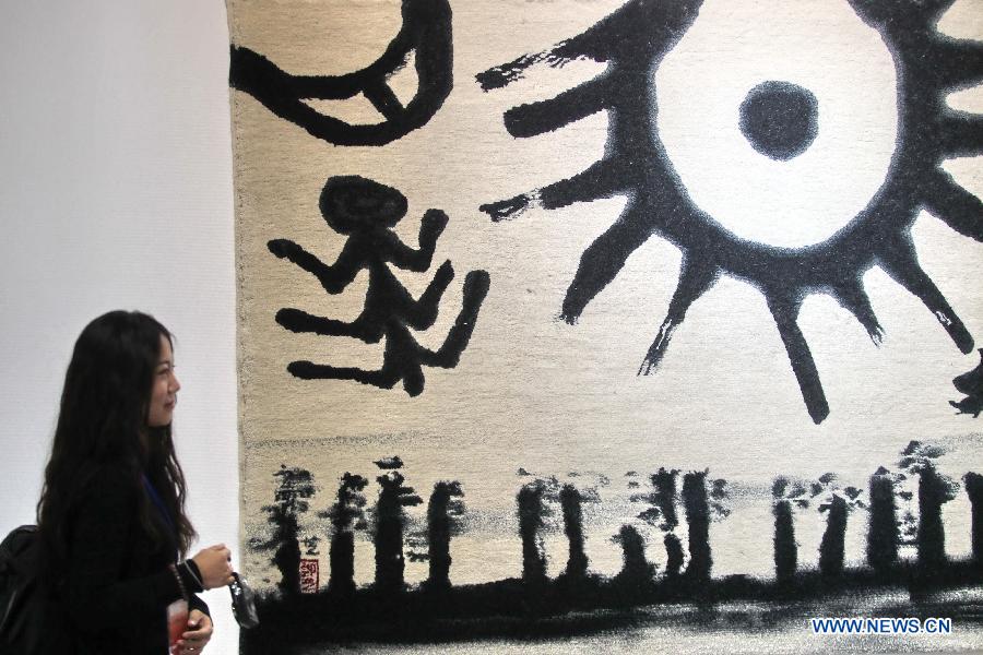 A visitor watches art works at the 7th From Lausanne to Beijing FiberArt Biennial Exhibition in Nantong, east China's Jiangsu Province, Nov. 5, 2012. The exhibition, displaying more than 300 pieces of works from 37 countries and regions, will be held here from Nov. 8 to Dec. 5 this year. (Xinhua/Xu Congjun)