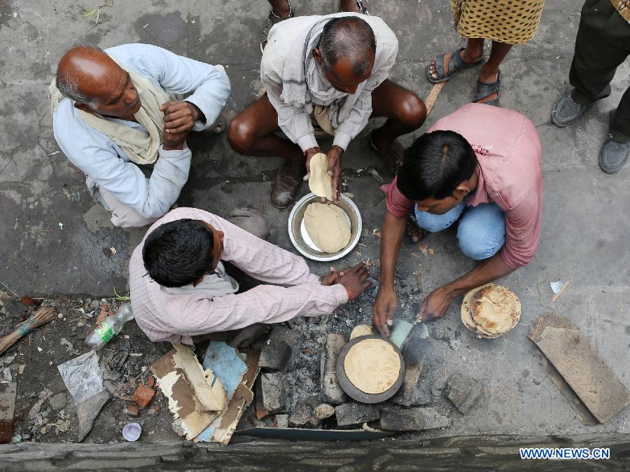 Rickshaw drivers make chapati for breakfast in East Patel Nagar, northern New Delhi, India, on Nov. 5, 2012. Rickshaw drivers' life is hard in the old city of New Delhi. (Xinhua/Li Yigang) 