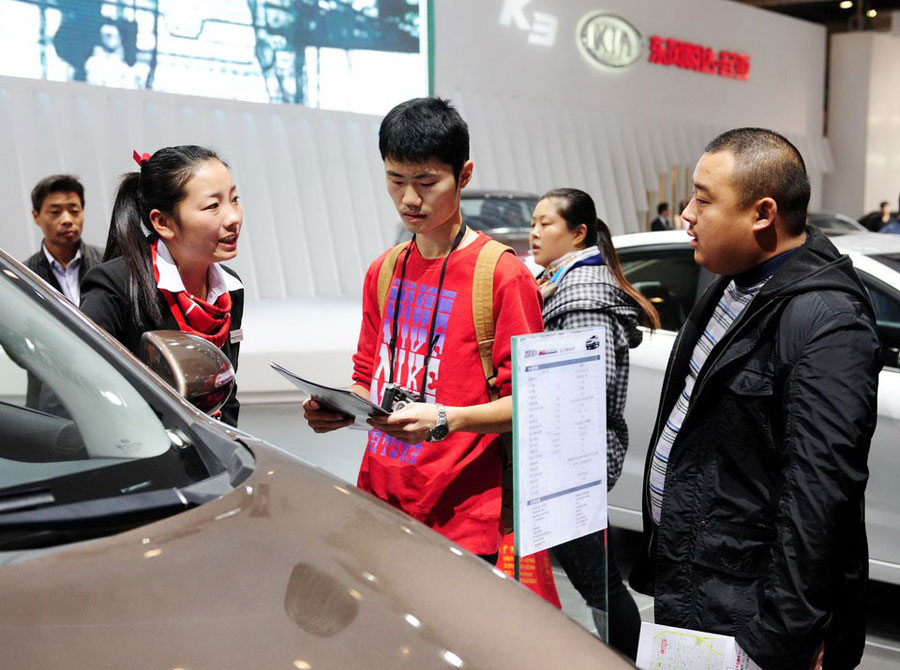 Visitors inquire about a car at the 5th Zhengzhou International Auto Exhibition in Zhengzhou, Henan province, Nov 2, 2012. [Photo/Xinhua]