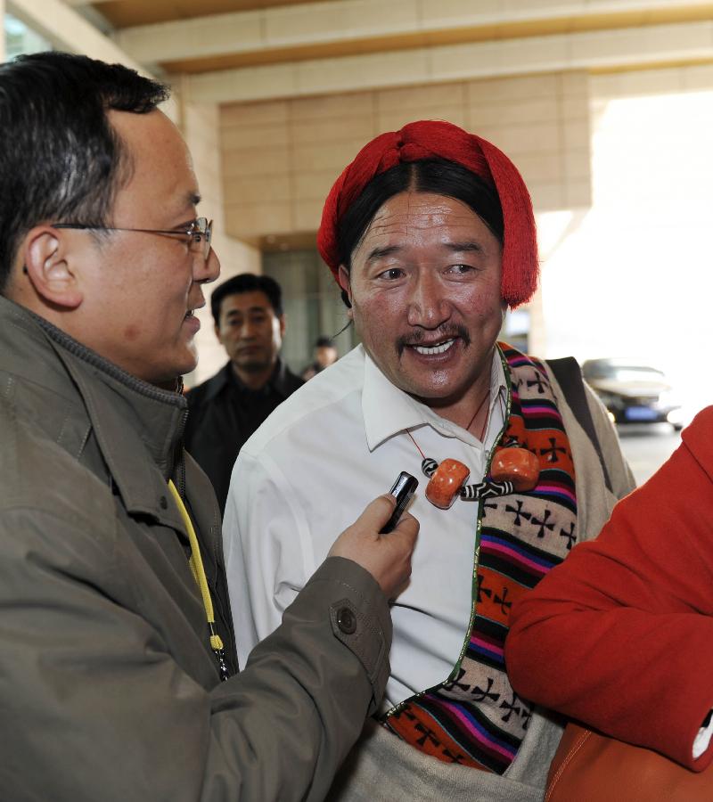 Caiwa, a delegate of the 18th National Congress of the Communist Party of China (CPC) from northwest China's Qinghai Province, speaks to a reporter upon arrival in Beijing, capital of China, Nov. 5, 2012. The 18th CPC National Congress will be opened in Beijing on Nov. 8. (Xinhua/Xie Huanchi)