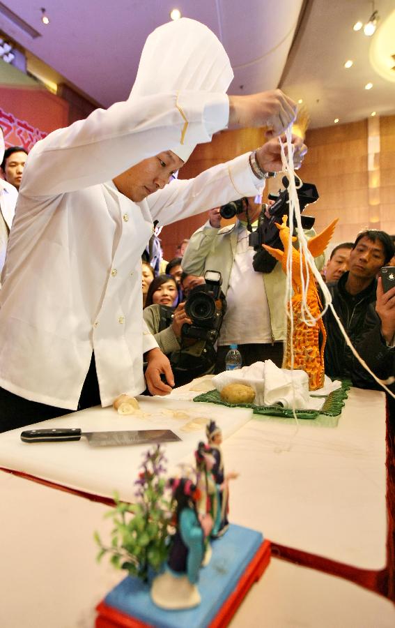 A chef performs cooking skills during a cooking skill exchange activity in Zhenjiang City, east China's Jiangsu Province, Nov. 6, 2012. The exchange activity, launched by restaurant associations from eight cities of Jiangsu Province along the Yangtze River, opened here on Tuesday. (Xinhua/Xu Peiqin) 