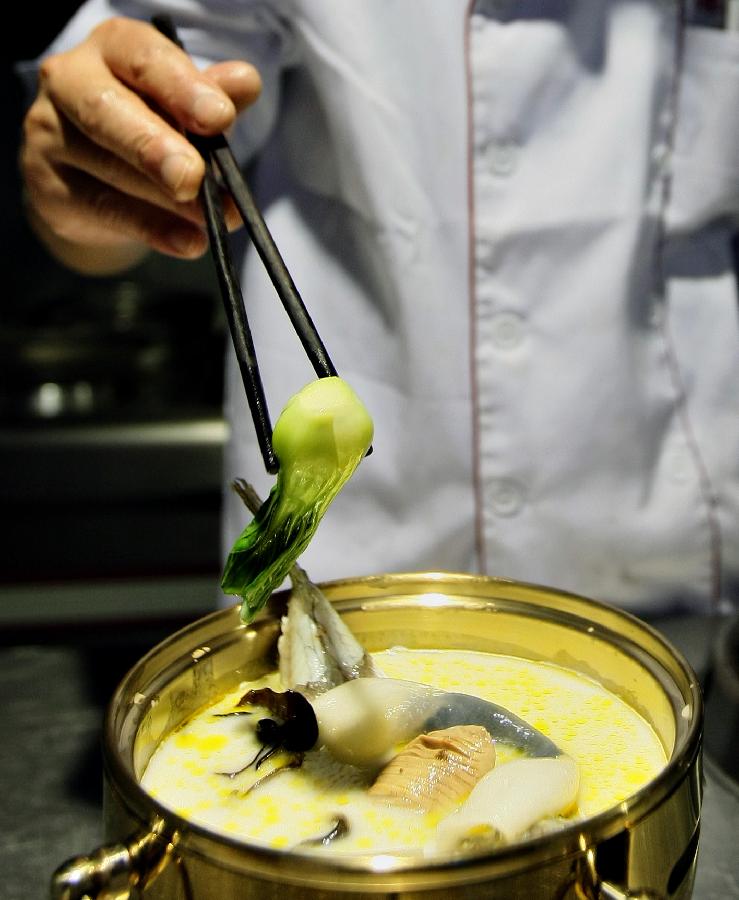 A chef performs cooking skills during a cooking skill exchange activity in Zhenjiang City, east China's Jiangsu Province, Nov. 6, 2012. The exchange activity, launched by restaurant associations from eight cities of Jiangsu Province along the Yangtze River, opened here on Tuesday. (Xinhua/Xu Peiqin) 