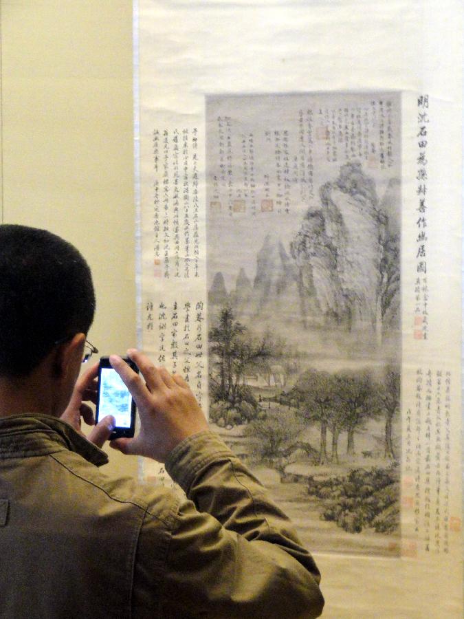 A visitor takes photos of ancient Chinese calligraphy and painting works at Suzhou Museum in Suzhou of east China's Jiangsu Province, Nov. 6, 2012. (Xinhua/Chen Yu)