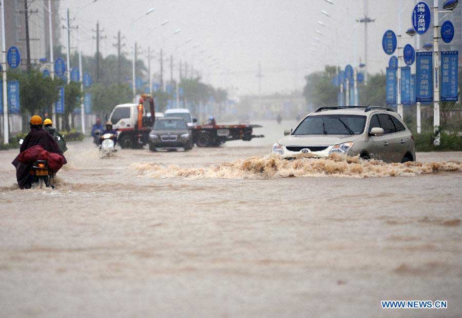 A car drives on a flooded road of Qionghai City, south China's Hainan Province, Nov. 6, 2012. Rainy weather appeared in some places of Qionghai City on Tuesday. (Xinhua/Meng Zhongde) 