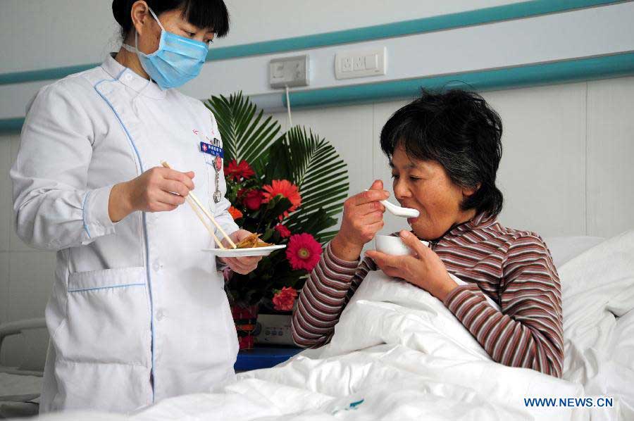 The rescued Japanese tourist (R) has dinner at a hospital in Huailai County, north China's Hebei Province, Nov. 6, 2012. Four Japanese tourists, accompanied by a Chinese tour guide, became trapped by a snowstorm on a snow-covered mountain in Hebei on Nov. 3. Three Japanese tourists who went missing have been confirmed dead, local authorities said Monday. (Xinhua)