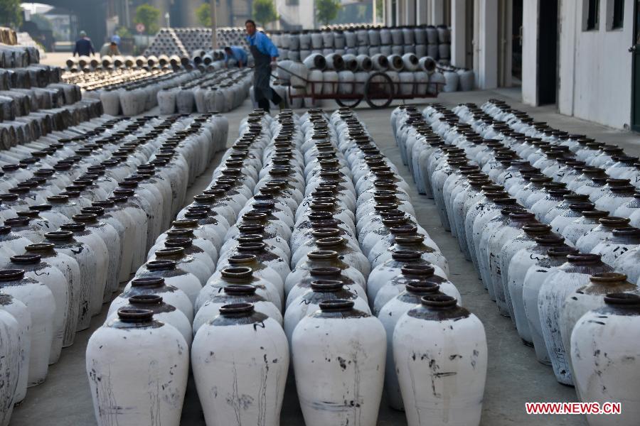 Workers check crocks of yellow rice wine under brewing at a rice wine brewery in Shaoxing, east China's Zhejiang Province, Nov. 7, 2012. (Xinhua/Xu Yu)