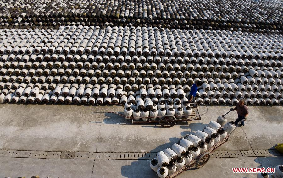 Workers check crocks of yellow rice wine under brewing at a rice wine brewery in Shaoxing, east China's Zhejiang Province, Nov. 7, 2012. (Xinhua/Xu Yu)