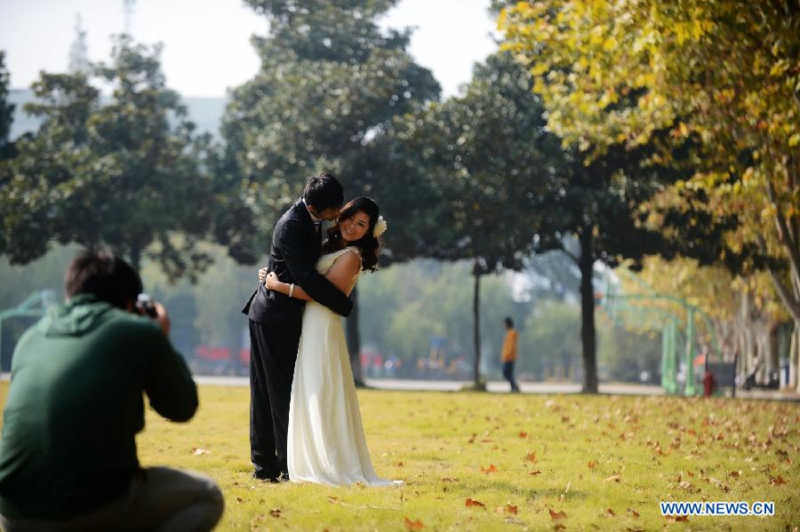 A couple pose for pictures on the campus of Yangzhou University in Yangzhou, east China's Jiangsu Province, Nov. 7, 2012. The beautiful scenery of Yangzhou University in late autumn attracted many people to come to enjoy. (Xinhua/Meng Delong)