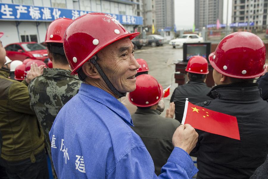 Construction workers watch TV reporting the opening ceremony of the 18th National Congress of the Communist Party of China (CPC) in southwest China's Chongqing, Nov. 8, 2012. The 18th CPC National Congress was opened in Beijing on Thursday. (Xinhua/Chen Cheng) 