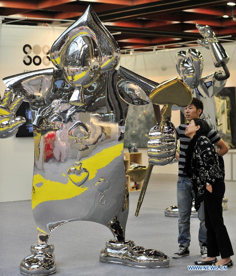 Visitors look at an art work displayed at the exhibiton "Art Taipei 2012" in Taipei, southeast China's Taiwan, Nov. 8, 2102. "Art Taipei 2012" will take place from Nov. 9 to 12 at Taipei World Trade Center, displaying more than 2,000 art works from 150 galleries of 15 countries and regions. (Xinhua/Wu Ching-teng) 