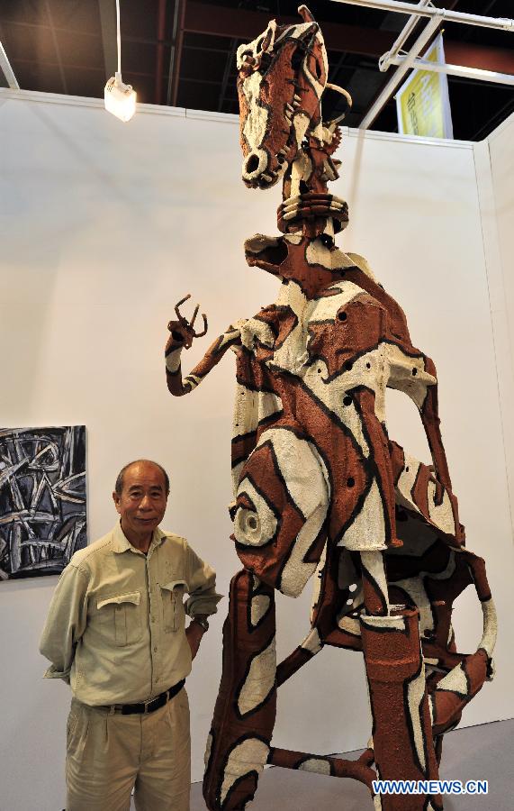 Artist A-Sun Wu of Taiwan poses next to his artwork at the exhibiton "Art Taipei 2012" in Taipei, southeast China's Taiwan, Nov. 8, 2102. "Art Taipei 2012" will take place from Nov. 9 to 12 at Taipei World Trade Center, displaying more than 2,000 art works from 150 galleries of 15 countries and regions. (Xinhua/Wu Ching-teng)