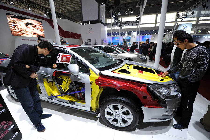 Visitors look at a car displayed at the 13th International Automobile Industry Exhibition in Hangzhou, capital of east China's Zhejiang Province, Nov. 7, 2012. 