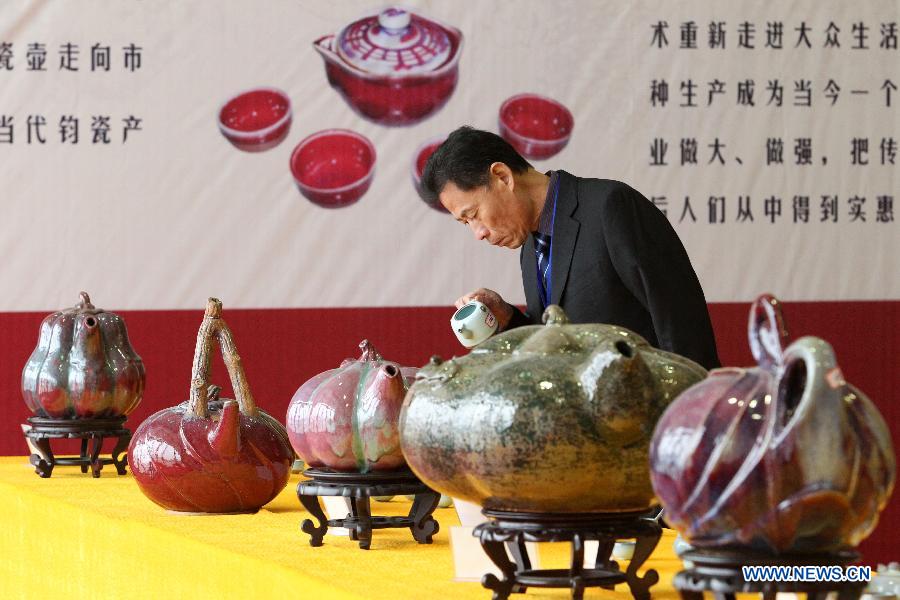 A man appreciates a pot displayed at Henan Jun porcelain pots design competition in Yuzhou City of Xuchang, central China's Henan Province, Nov. 10, 2012. Jun porcelain, one of the five top porcelains in China, is famous for the amazing change of its color during the process of firing in kilns. (Xinhua/Niu Shupei)