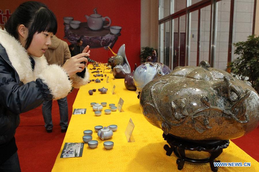 A woman takes pictures of a pot displayed at Henan Jun porcelain pots design competition in Yuzhou City of Xuchang, central China's Henan Province, Nov. 10, 2012. Jun porcelain, one of the five top porcelains in China, is famous for the amazing change of its color during the process of firing in kilns. (Xinhua/Niu Shupei)