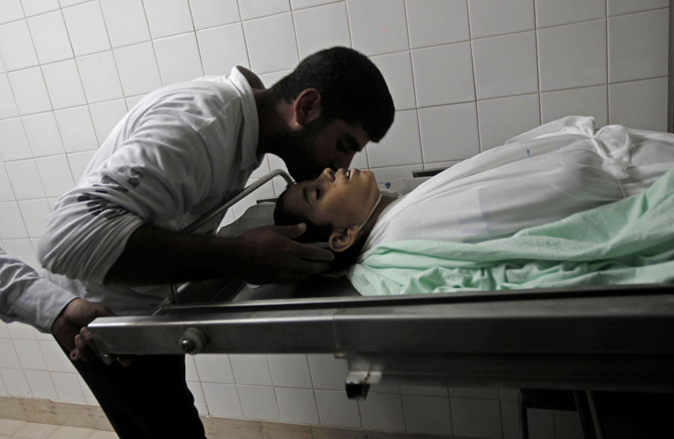Relative kisses goodbye to the body of a Palestinian boy in the morgue of a hospital in Khan Yunis, south Gaza Strip, Nov. 8, 2012. The boy, named Ahmad Abo Daqa, was killed in an Israeli airstrikes on Palestinian areas in southeast Gaza Strip, medical sources and witnesses said on Thursday. (Xinhua/AFP)