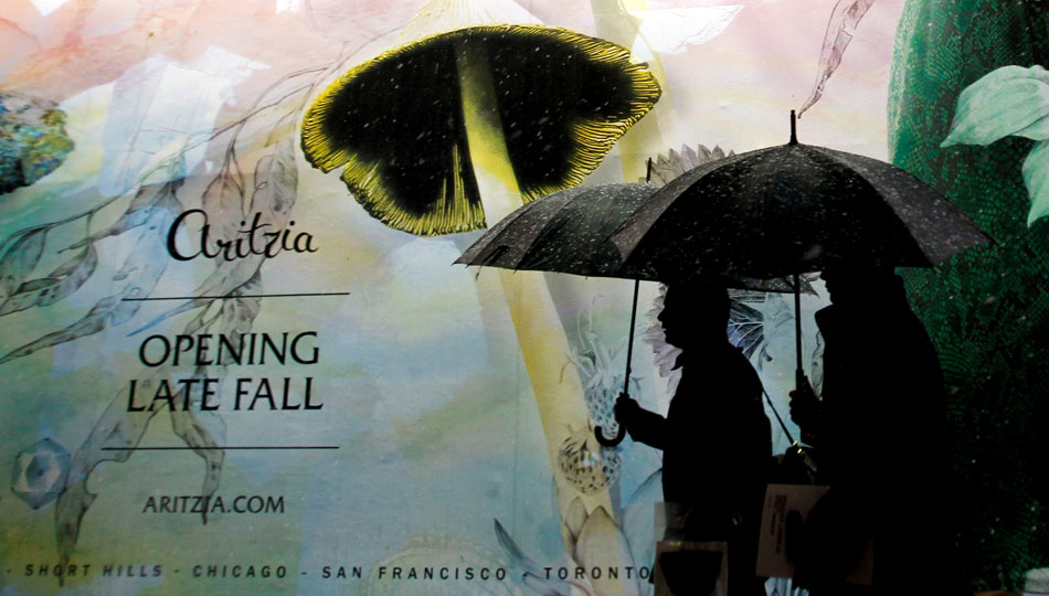 Pedestrians walk by a billboard on the 5th Avenue in New York, the United States, Nov. 7, 2012. As New Jersey and New York are still trying to recover from the damage created by Hurricane Sandy, a Nor'easter named Winter Storm Athena dropped snow and rain on the Northeast on Wednesday, also bringing dangerous winds and knocking out power. (Xinhua/Wu Jingdan)