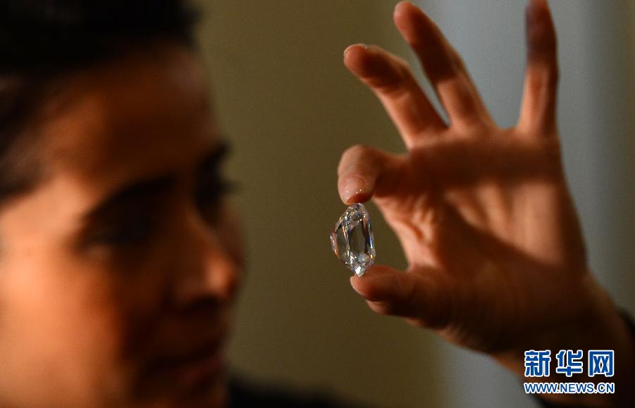 An employee poses with the Archduke Joseph Diamond during an auction preview at Christie's in Geneva, Switzerland, on Nov. 8, 2012. The 76.02 carat diamond is expected to be sold for over 15 million U.S. dollars when it is auctioned on Nov. 13. (Xinhua/Wang Siwei)