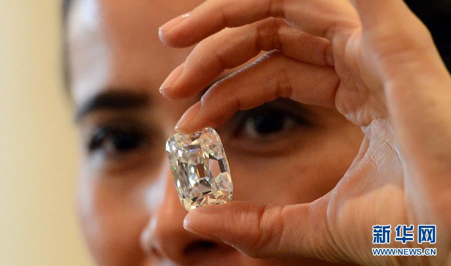 An employee poses with the Archduke Joseph Diamond during an auction preview at Christie's in Geneva, Switzerland, on Nov. 8, 2012. The 76.02 carat diamond is expected to be sold for over 15 million U.S. dollars when it is auctioned on Nov. 13. (Xinhua/Wang Siwei)