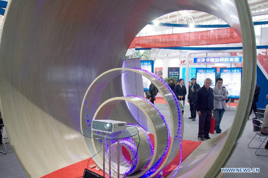 Visitors listen to the introduction of a latest fibreglass sonim pipe at the "2012 International Building Materials and Decoration Fair" in north China's Tianjin Municipality, Nov. 9, 2012. The fair, with the participation of more than 800 enterprises, opened here on Friday. (Xinhua/Wang Qingyan)