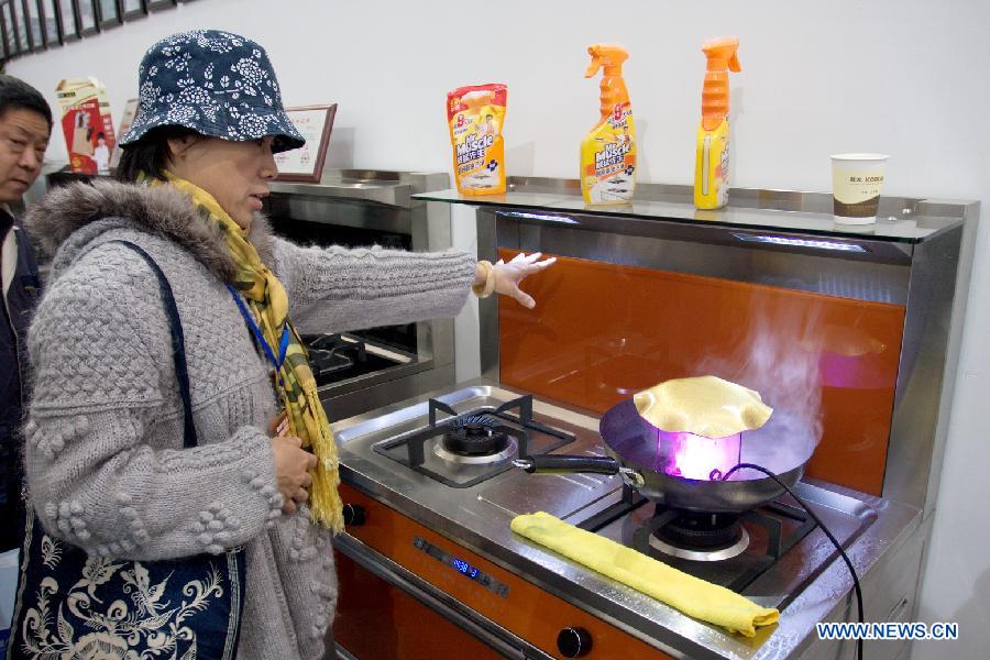 Visitors inquires about the latest kitchen wares at the "2012 International Building Materials and Decoration Fair" in north China's Tianjin Municipality, Nov. 9, 2012. The fair, with the participation of more than 800 enterprises, opened here on Friday. (Xinhua/Wang Qingyan)