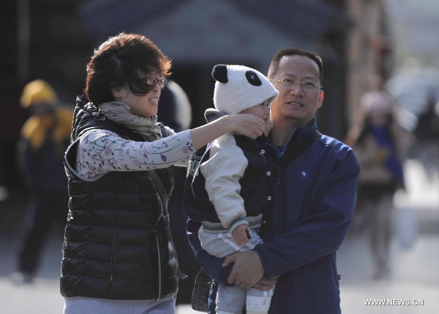 Tourists walk in strong wind at the Tiantan Park in Beijing, capital of China, Nov. 11, 2012. Beijing experienced windy weather and a sharp fall in temperature on Sunday following a rainfall the previous day. (Xinhua/Li Wen) 