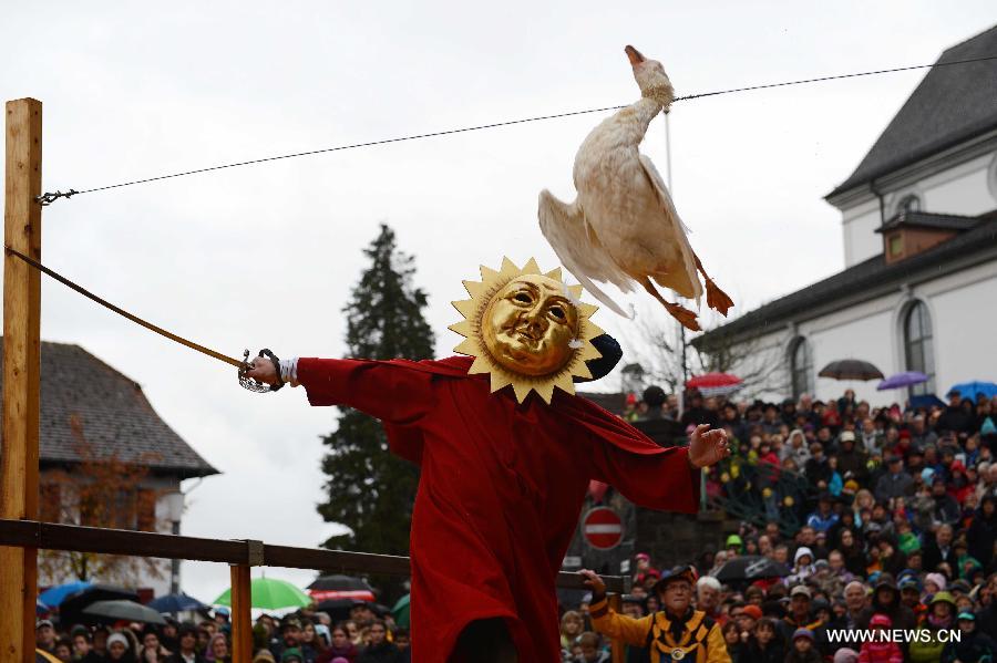 A contestant participates in the Gansabhauet in Sursee, Nov. 11, 2012. Gansabhauet (cutting down the goose from a rope) was held in the town of Sursee near Lucerne, central Switzerland on Sunday to celebrate the St. Martin's Day. (Xinhua/Wang Siwei)