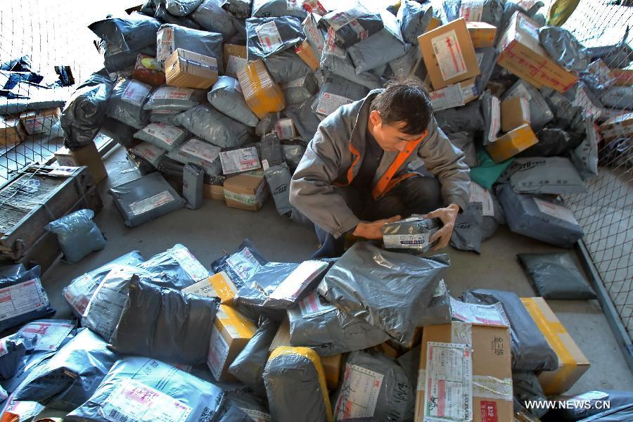 A working staff distributes packs in an express company in Nantong, east China's Jiangsu Province, Nov. 12, 2012. The annual Single's Day which falls on Nov. 11 has become a shopping festival under a continuous sales promotion of e-business groups. Great discounts resulted in a sharp increase of online trades which cause enormous pressure on express service. (Xinhua/Xu Congjun)  