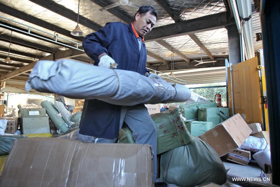 A working staff distributes packs in an express company in Nantong, east China's Jiangsu Province, Nov. 12, 2012. The annual Single's Day which falls on Nov. 11 has become a shopping festival under a continuous sales promotion of e-business groups. Great discounts resulted in a sharp increase of online trades which cause enormous pressure on express service. (Xinhua/Xu Congjun) 