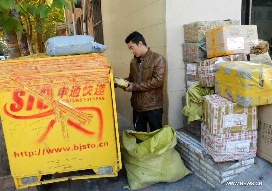 A working staff from an express company loads packs in Xicheng District of Beijing, capital of China, Nov. 12, 2012. The annual Single's Day which falls on Nov. 11 has become a shopping festival under a continuous sales promotion of e-business groups. Great discounts resulted in a sharp increase of online trades which cause enormous pressure on express service. (Xinhua/Wang Zhen)  