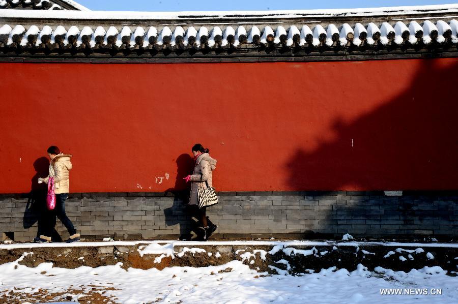 Citizens walk on snow-covered road in Shenyang, capital of northeast China's Liaoning Province, Nov. 12, 2012. A cold front is sweeping across the country's northern areas, bringing heavy snow and blizzards. (Xinhua/Zhang Wenkui) 