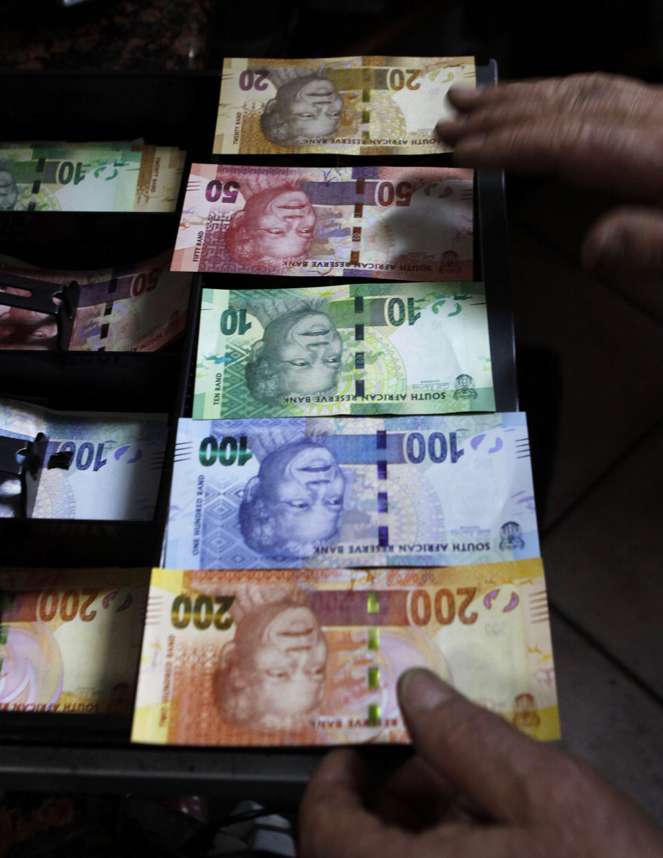 A shop owner shows off South Africa's new banknotes, which features an image of former president Nelson Mandela on the front and images of the country's "Big Five" wild animals on the reverse, as they go into official circulation in Pretoria on November 6, 2012.(Xinhua/AP)