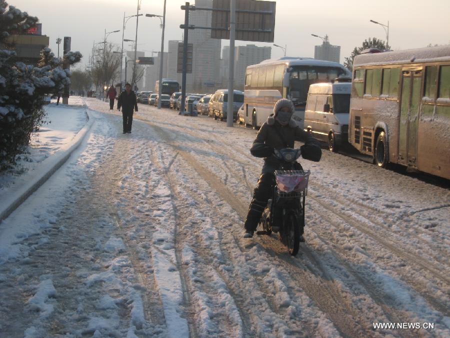 Vehicles and pedestrians make their way on a snow-covered road in Shenyang, capital of northeast China's Liaoning Province, Nov. 12, 2012. A cold front is sweeping across the country's northern areas, bringing heavy snow and blizzards. (Xinhua/Cao Yang) 