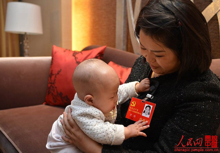 Luo Wei, a deputy to the 18th National Congress of the Communist Party of China, takes care of her five-month-old daughter in a hotel after a group discussion in Beijing on Nov. 10, 2012. Luo, who took her baby to Beijing as she is still breastfeeding, is the youngest deputy of Sichuan province delegation. She donated 55 percent of her liver to save the life of an unrelated person in 2005. (Photo/ People’s Daily Online)