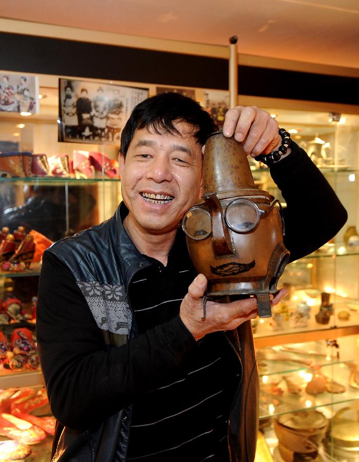 Tong Fucun shows a piece of his collection in Taiyuan, capital of north China's Shanxi Province, Nov.11, 2012. (Xinhua/Yan Yan) 