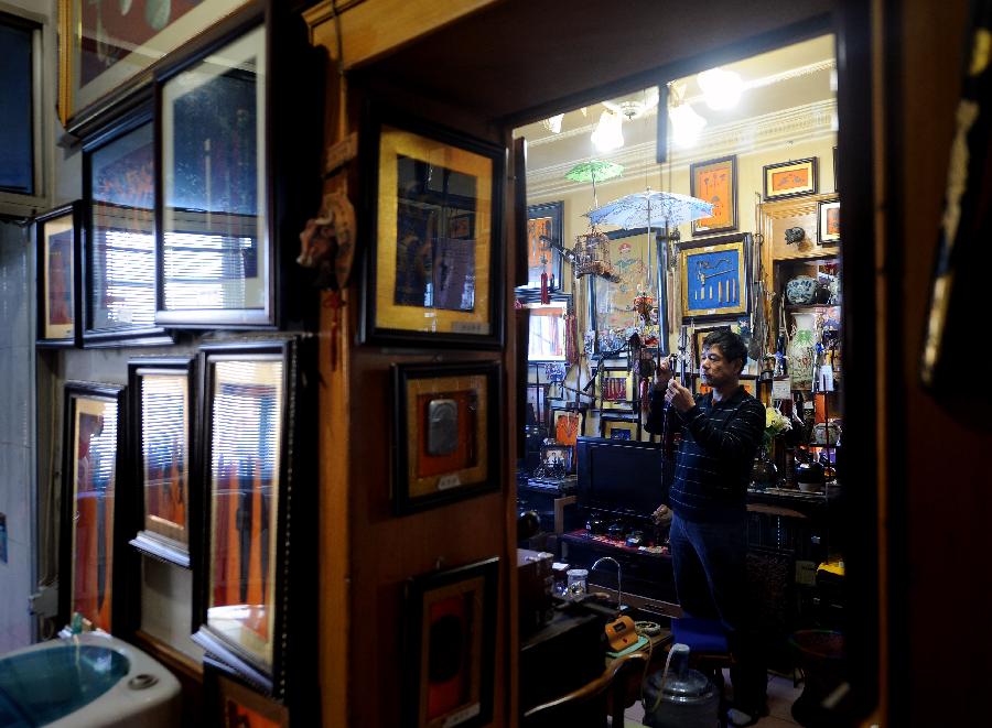 Tong Fucun views a piece of his collection in Taiyuan, capital of north China's Shanxi Province, Nov.11, 2012. (Xinhua/Yan Yan) 