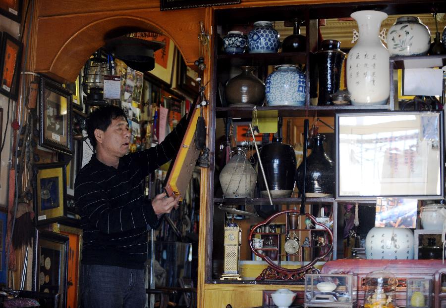 Tong Fucun categorizes his collection in Taiyuan, capital of north China's Shanxi Province, Nov.11, 2012. (Xinhua/Yan Yan) 