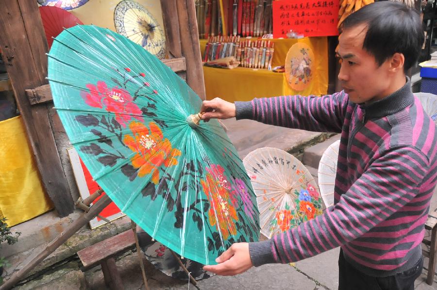 A craftsman processes oil-paper umbrellas at a workshop in Xixiu District of Anshun City, southwest China's Guizhou Province, Nov. 12, 2012. Made of oiled paper and bamboo frame, oil-paper umbrella is a traditional Chinese handicraft. The skills of making oil-paper umbrellas were introduced to Guizhou in early Ming Dynasty (1368-1644). (Xinhua/Huang Yong) 