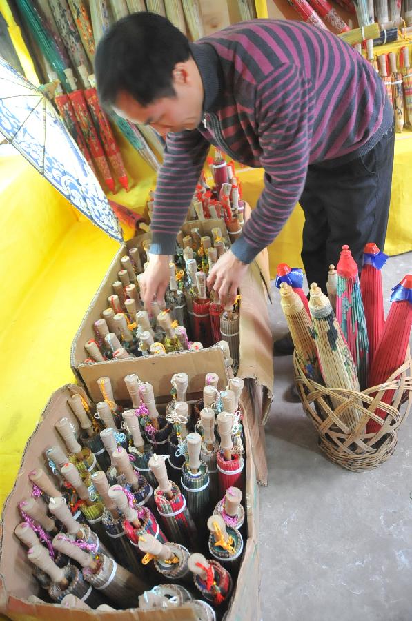 A craftsman processes oil-paper umbrellas at a workshop in Xixiu District of Anshun City, southwest China's Guizhou Province, Nov. 12, 2012. Made of oiled paper and bamboo frame, oil-paper umbrella is a traditional Chinese handicraft. The skills of making oil-paper umbrellas were introduced to Guizhou in early Ming Dynasty (1368-1644). (Xinhua/Huang Yong) 