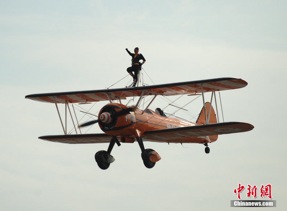 Photo taken on Nov. 11, 2012 shows the wingwalkers of Beritling Jet Tem, a famous European aerobatic team, putting on wonderful performance on the wings of biplaines during a test flight for the Airshow China 2012. The airshow kicked off on Tuesday morning in south China’s Zhuhai. (Photo/Chinanews.com)