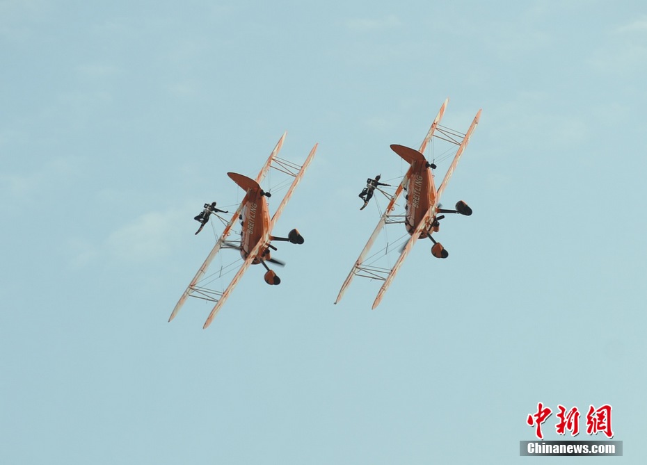 Photo taken on Nov. 11, 2012 shows the wingwalkers of Beritling Jet Tem, a famous European aerobatic team, putting on wonderful performance on the wings of biplaines during a test flight for the Airshow China 2012. The airshow kicked off on Tuesday morning in south China’s Zhuhai. (Photo/Chinanews.com)