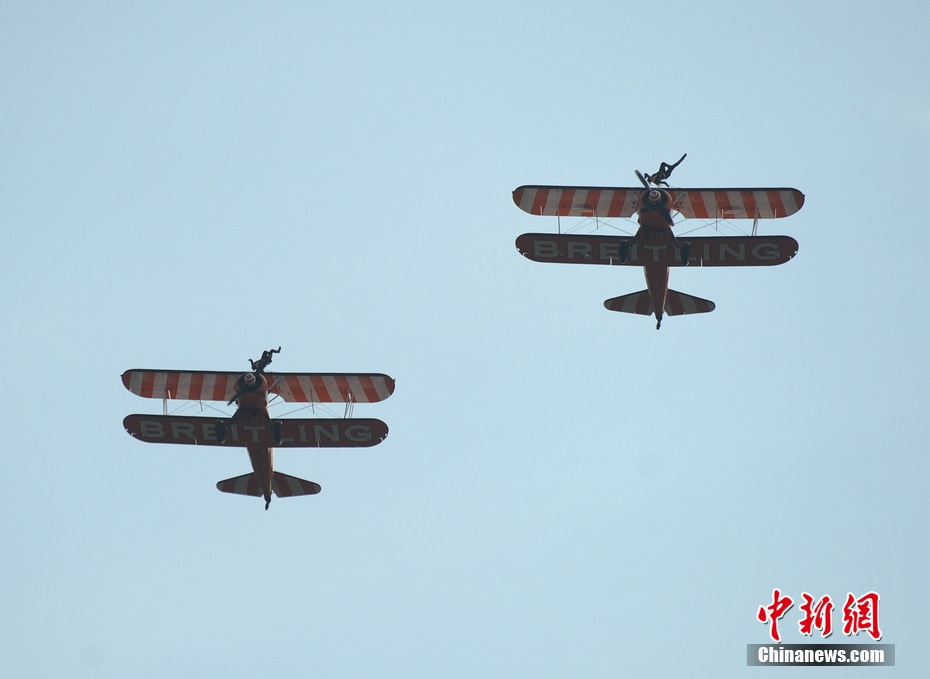 Photo taken on Nov. 11, 2012 shows the wingwalkers of Beritling Jet Tem, a famous European aerobatic team, putting on wonderful performance on the wings of biplaines during a test flight for the Airshow China 2012. The airshow kicked off on Tuesday morning in south China’s Zhuhai. (Photo/Chinanews.com)