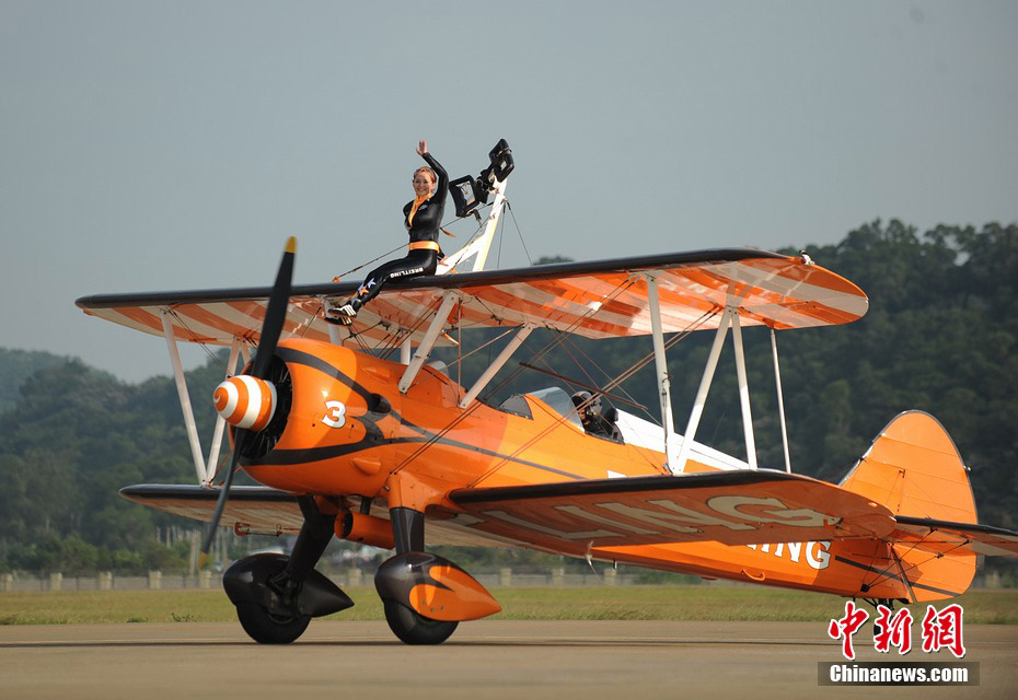 Photo taken on Nov. 11, 2012 shows the wingwalkers of Beritling Jet Tem, a famous European aerobatic team, putting on wonderful performance on the wings of biplaines during a test flight for the Airshow China 2012. The airshow kicked off on Tuesday morning in south China’s Zhuhai. (Photo/Chinanews.com)