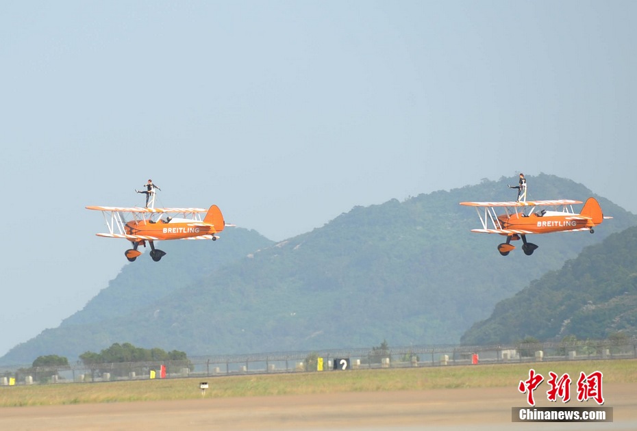 Photo taken on Nov. 11, 2012 shows the wingwalkers of Beritling Jet Tem, a famous European aerobatic team, putting on wonderful performance on the wings of biplaines during a test flight for the Airshow China 2012. The airshow kicked off on Tuesday morning in south China’s Zhuhai. (Photo/Chinanews.com)