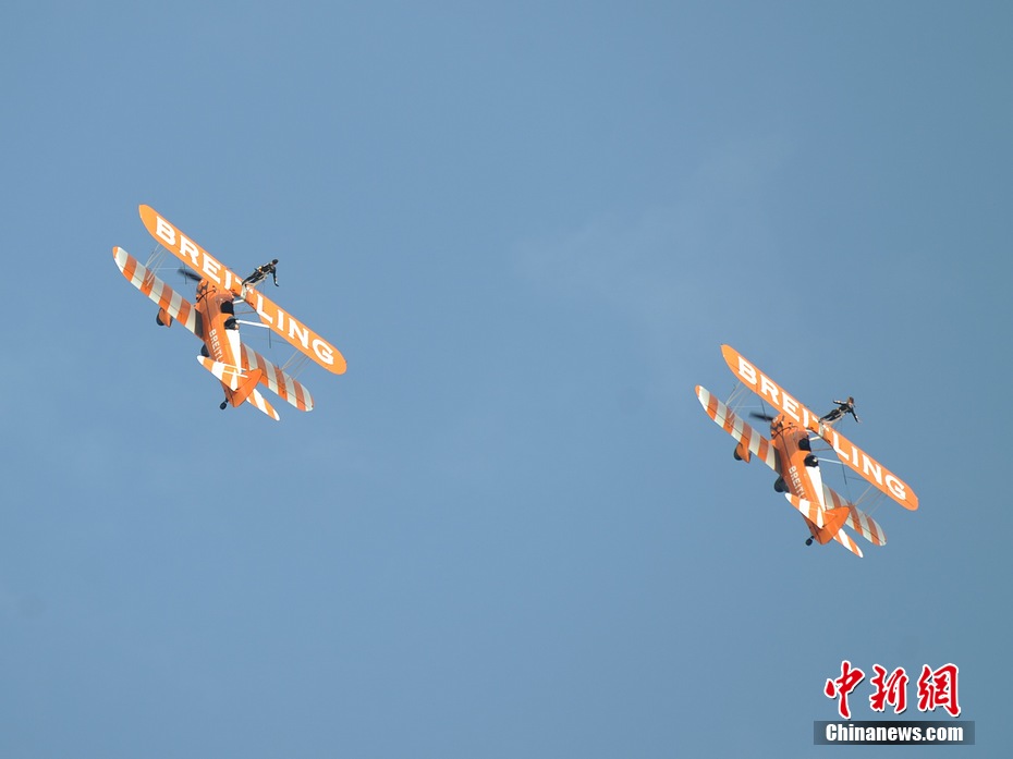 Photo taken on Nov. 11, 2012 shows the wingwalkers of Beritling Jet Tem, a famous European aerobatic team, putting on wonderful performance on the wings of biplaines during a test flight for the Airshow China 2012. The airshow kicked off on Tuesday morning in south China’s Zhuhai. (Photo/Chinanews.com)