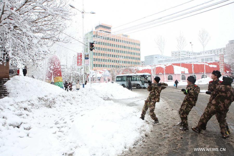 Firefighers clean snow on a tree in Hegang, northeast China's Heilongjiang Province, Nov. 13, 2012. Snowstorms in recent days have affected road traffic and caused difficulties to local people in northeast China. (Xinhua/Fang Baoshu) 