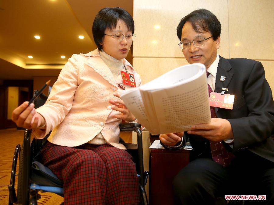 Hou Jingjing (L), a delegate to the 18th National Congress of the Communist Party of China (CPC), and another delegate Wang Sheng read report at hotel in Beijing, capital of China, Nov. 11, 2012.(Xinhua/Chen Jianli)