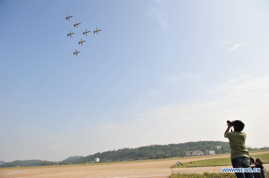 Photographers take photo of the flight display of the PLA August 1st Aerobatic Team during the 9th China International Aviation and Aerospace Exhibition in Zhuhai, south China's Guangdong Province, Nov. 11, 2012. The exhibition has attracted a large number of photograghers. Some of them are from media, some are from aviation industry corporations and others are big fans of aviation. (Xinhua/Yang Guang)