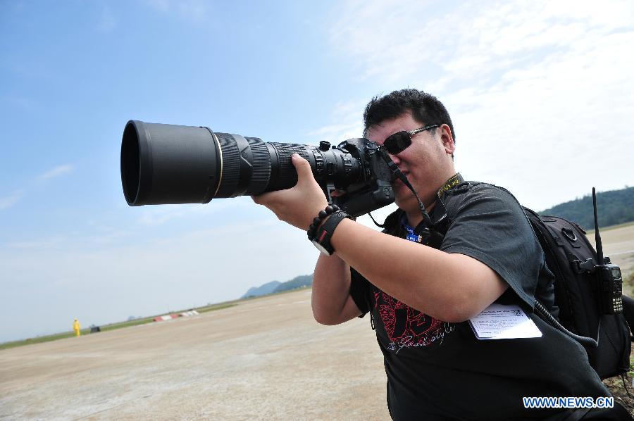 A photographer takes photo of a flight display during the 9th China International Aviation and Aerospace Exhibition in Zhuhai, south China's Guangdong Province, Nov. 11, 2012. The exhibition has attracted a large number of photograghers. Some of them are from media, some are from aviation industry corporations and others are big fans of aviation. (Xinhua/Yang Guang)