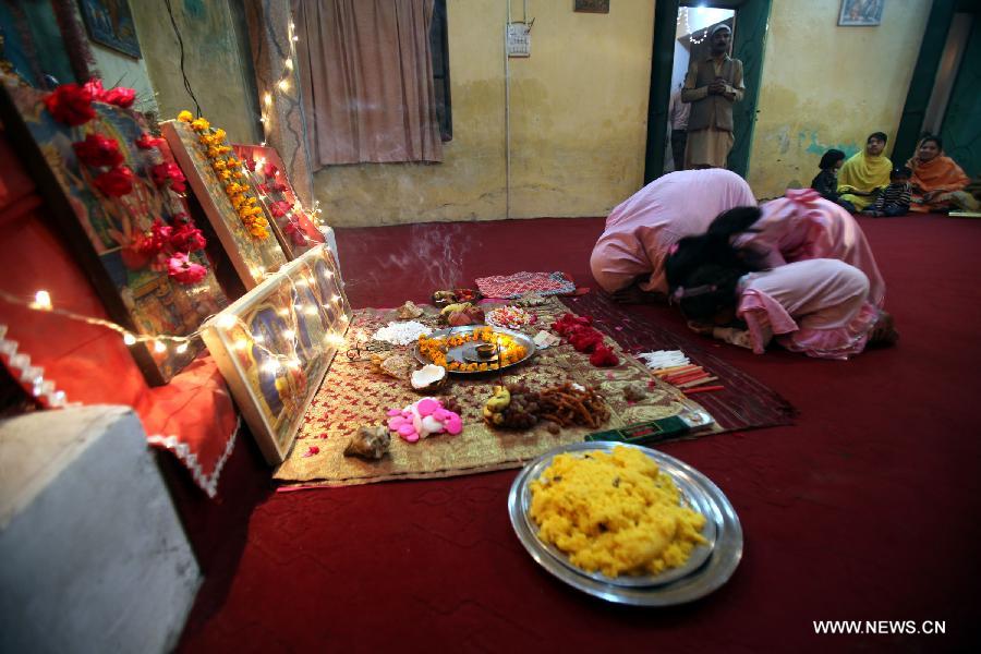 A Pakistani Hindu family take part in a ritual to celebrate the Hindu festival of Diwali at a temple, in northwest Pakistan's Peshawar, on Nov. 13, 2012. People light lamps and offer prayers to the goddess of wealth Lakshmi in the Hindu festival of Diwali, the festival of lights, which falls on Nov. 13 this year. (Xinhua/Umar Qayyum)